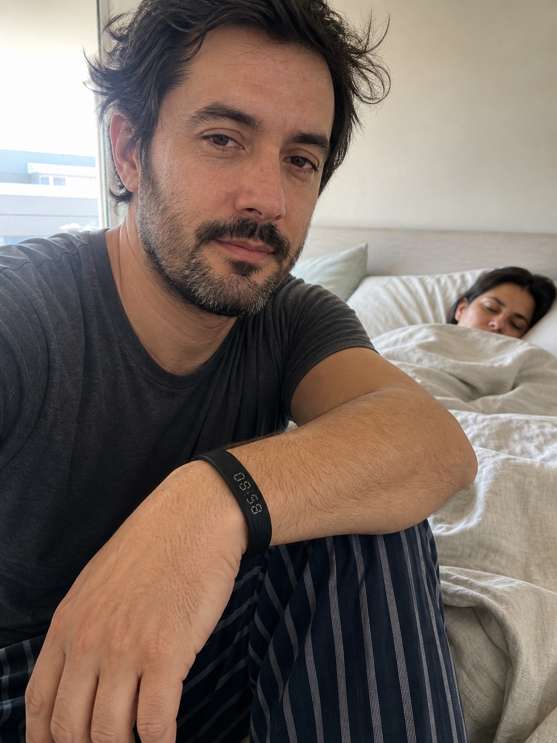 Hombre sentado junto a la cama con BIVRA en la muñeca
